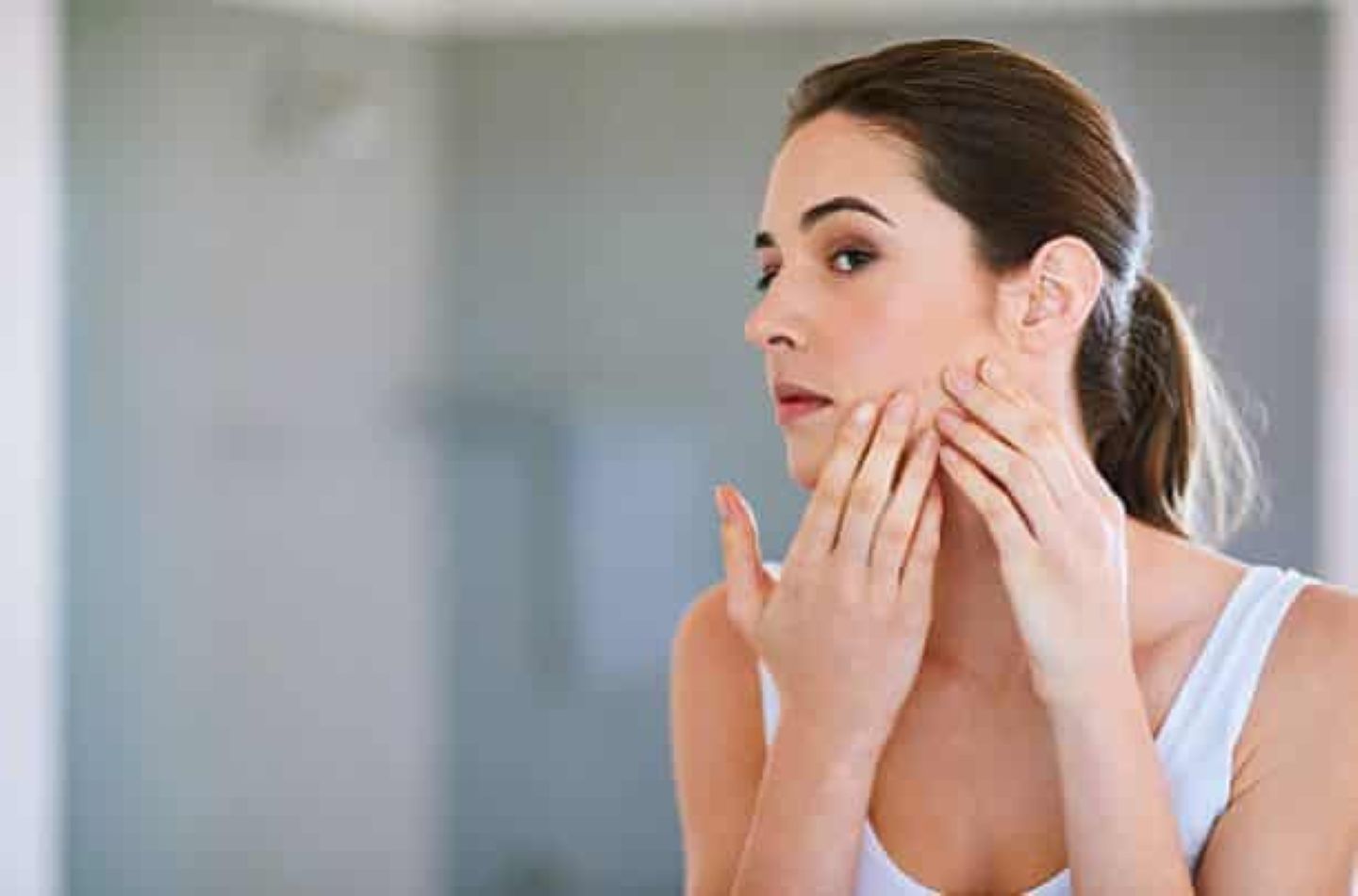 woman in mirror looking at lifted jawline