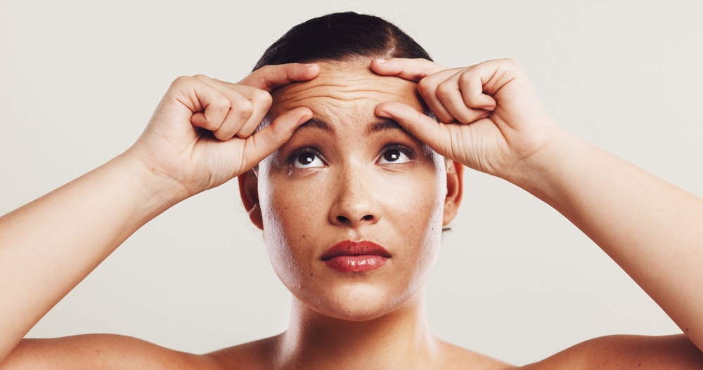 woman focusing on forehead wrinkles