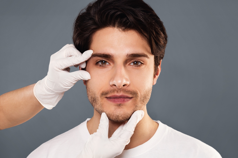 Man with med spa professional inspecting under eye area