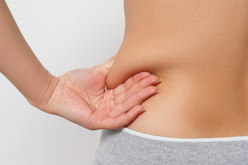 woman pinching her love handles