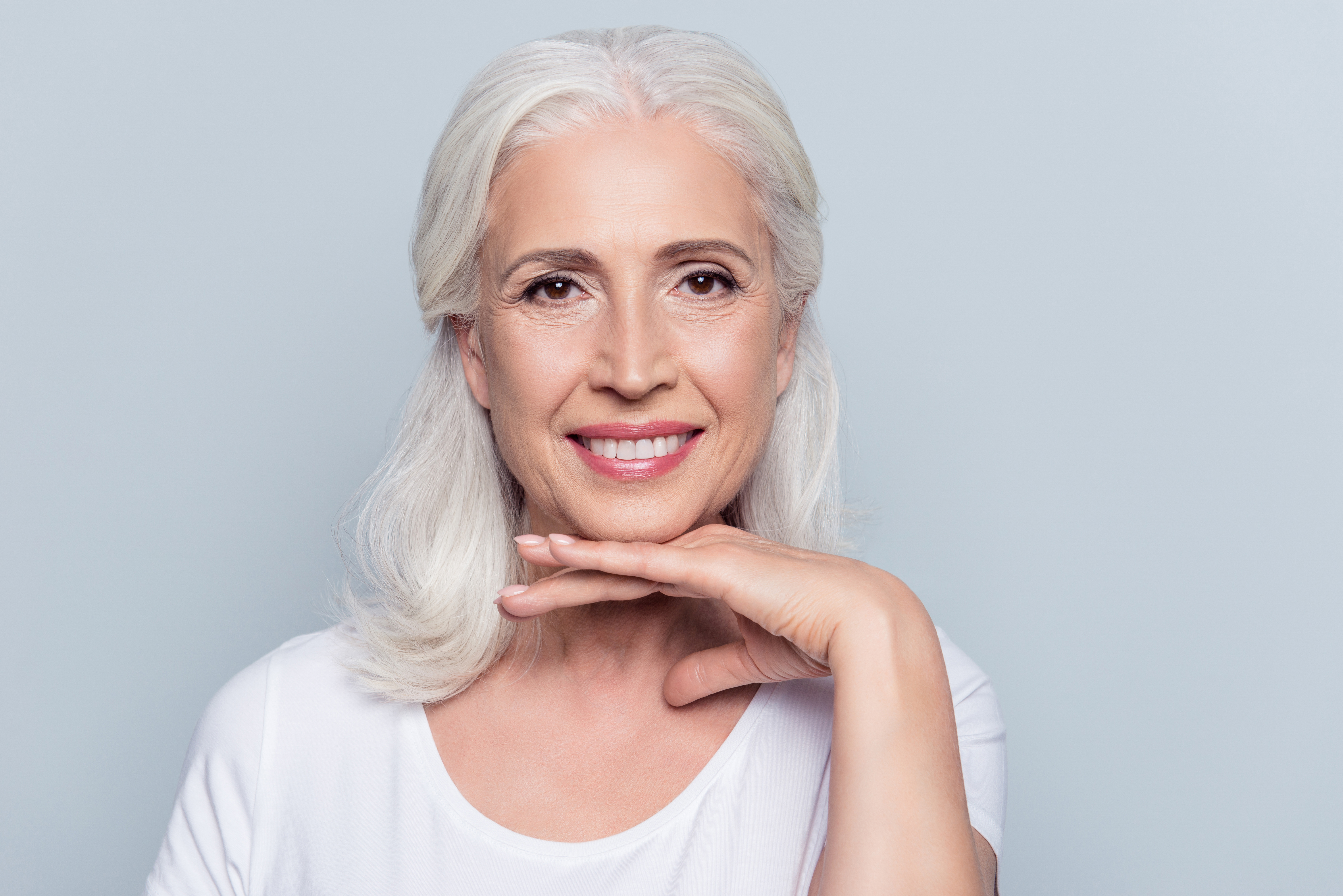 older woman with wrinkle free forehead smiling at camera