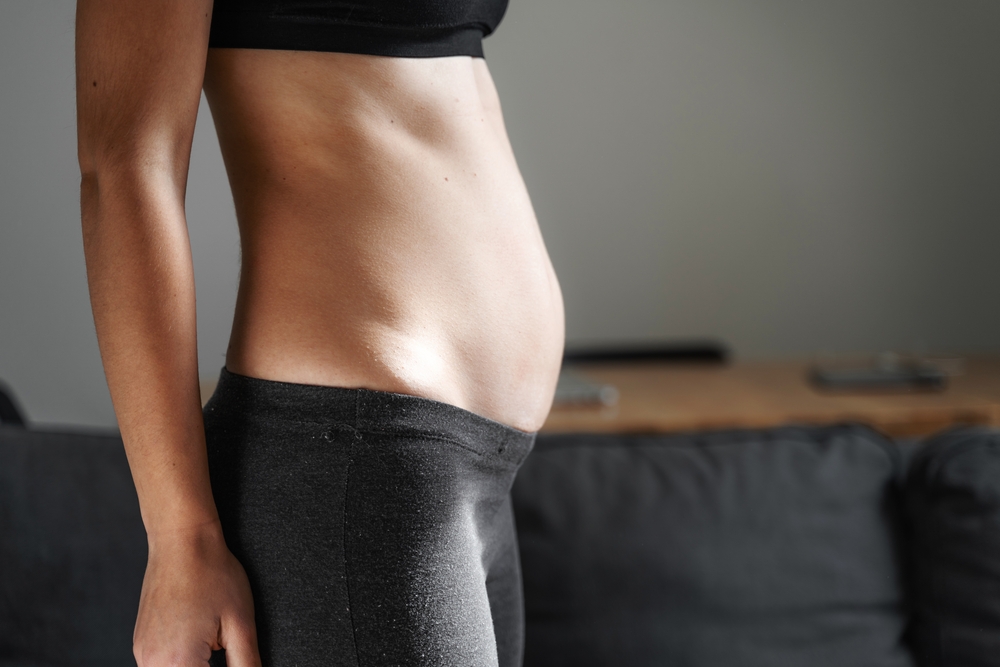 Side view of a postpartum woman with diastasis recti - good candidate for EmSculpt NEO in NYC